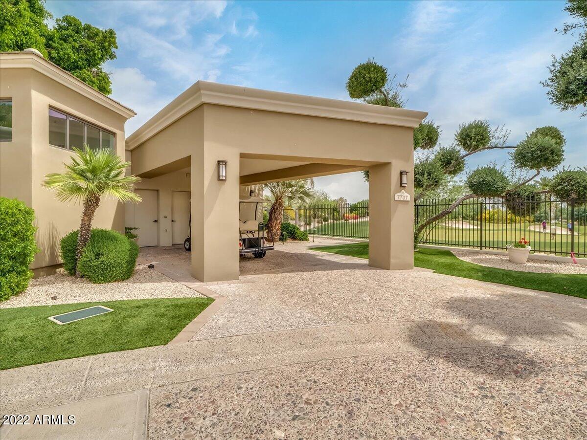 6000 East Camelback Road, Unit 7707 Scottsdale, AZ 85251 - Photo 41 of 42 a front view of a house with a yard and potted plants