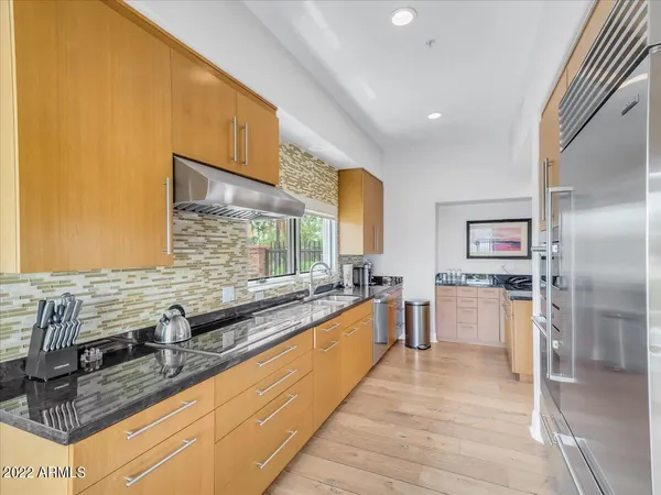 a large kitchen with stainless steel appliances granite countertop a sink and cabinets
