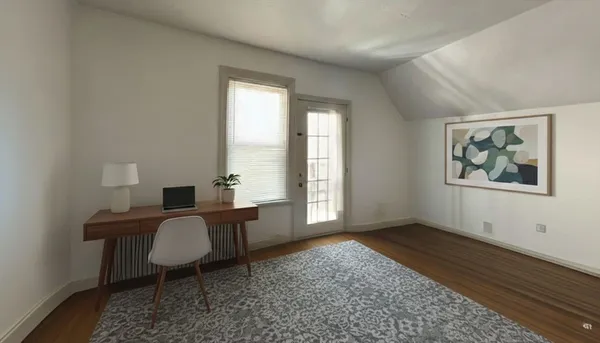 a view of a workspace with furniture and a window