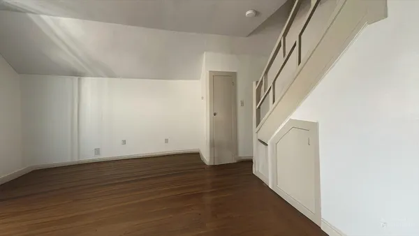a view of a hallway with wooden floor and entryway