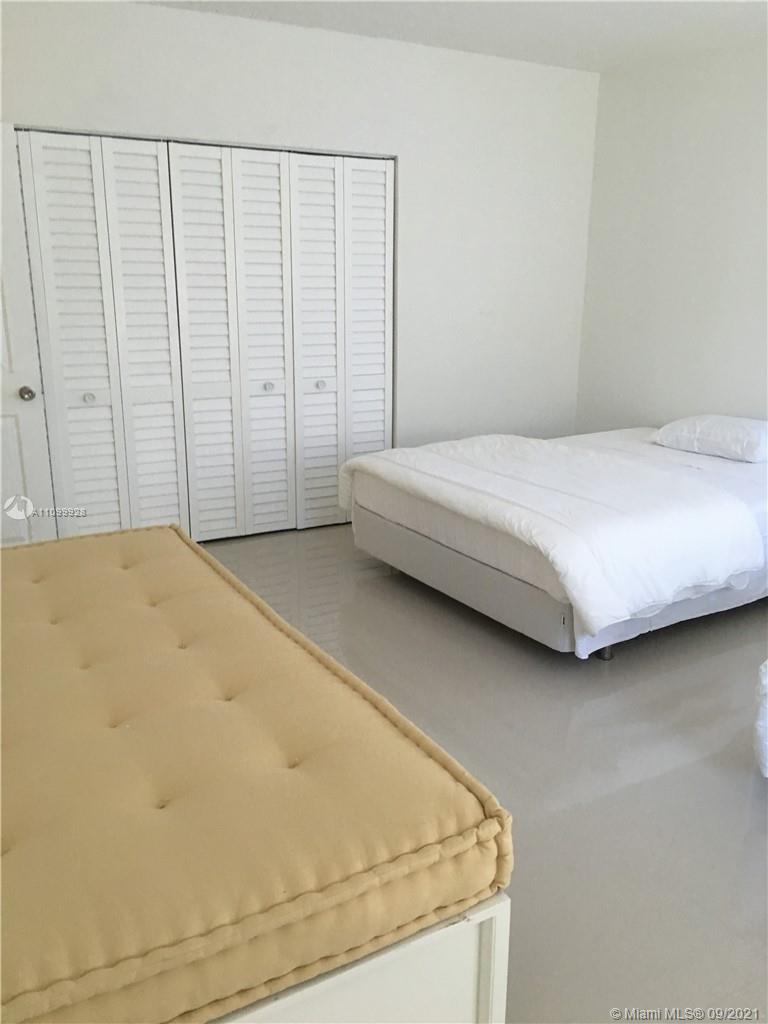 60 Park Drive, Unit D Bal Harbour, FL 33154 - Photo 11 of 13 a bedroom with a bed and a cabinet