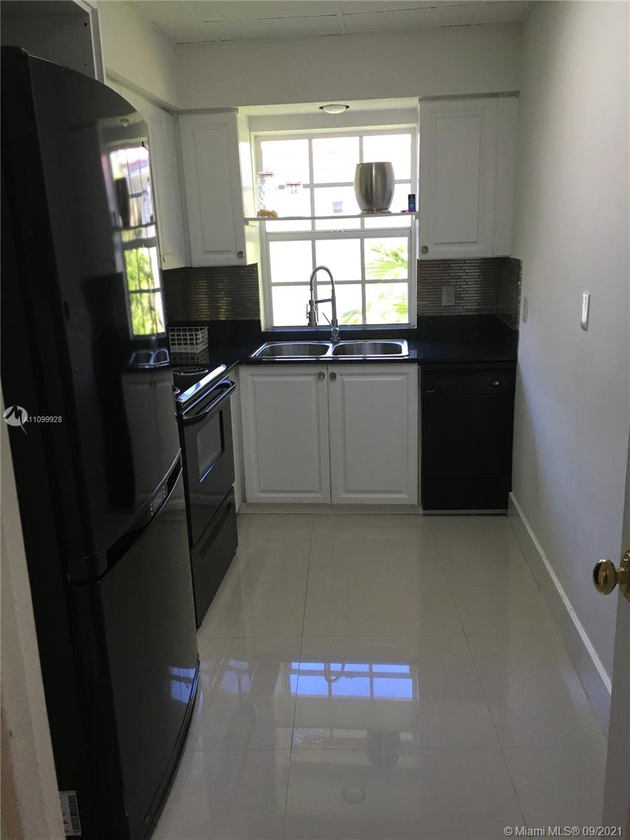 60 Park Drive, Unit D Bal Harbour, FL 33154 - Photo 5 of 13 a kitchen with granite countertop a refrigerator a stove a sink and a window