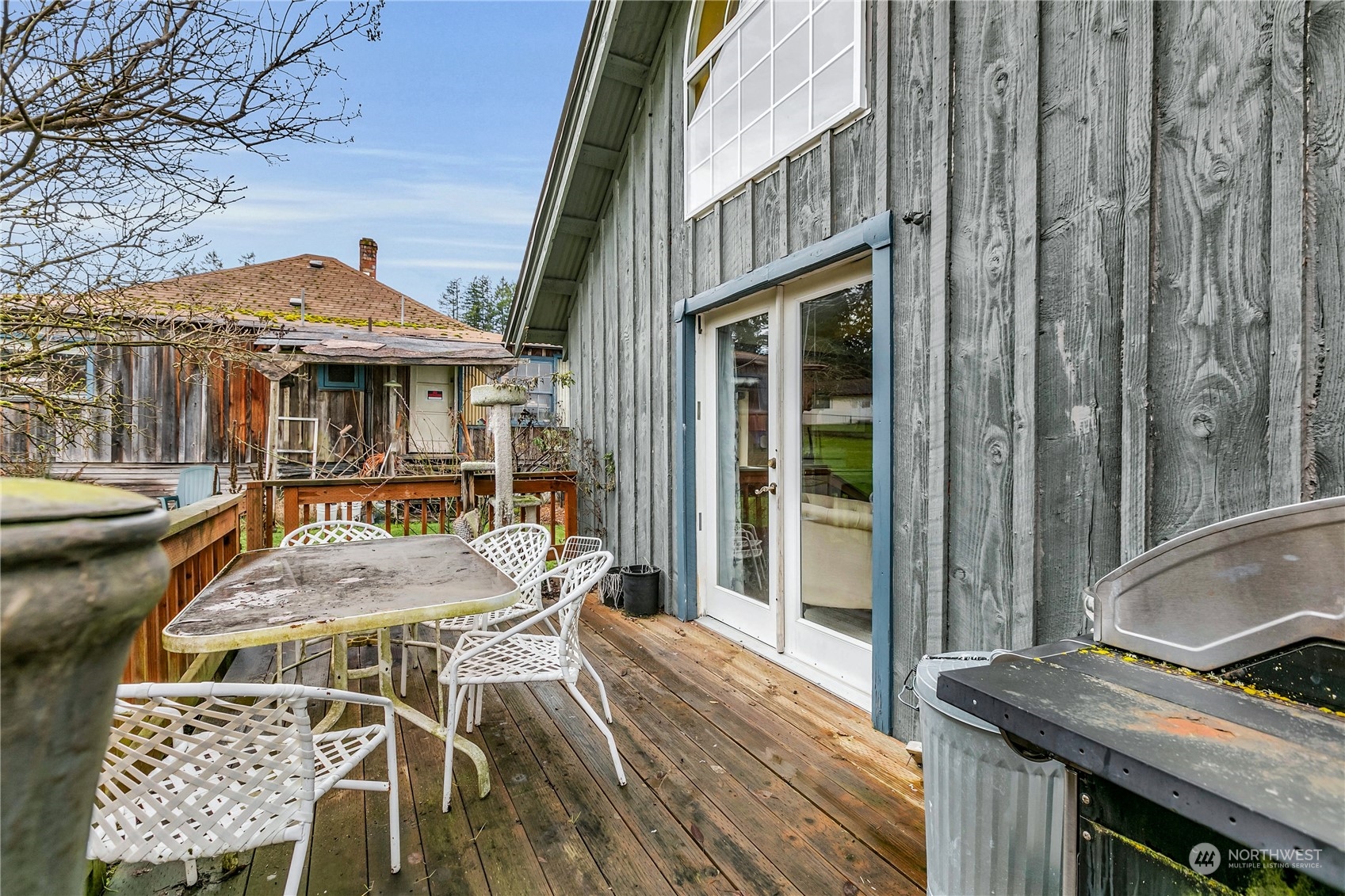 25115 72nd Avenue East Graham, WA 98338 - Photo 16 of 24 a view of a patio with table and chairs with wooden floor and fence