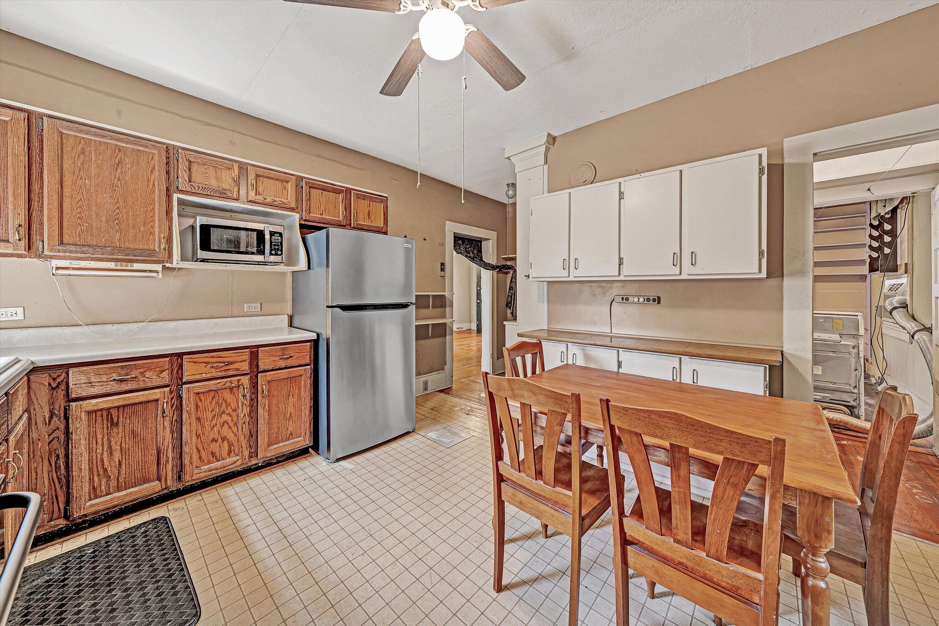 4787 Glade Creek Road Roanoke, VA 24012 - Photo 12 of 37 a kitchen with stainless steel appliances granite countertop a refrigerator a stove a sink dishwasher and white cabinets with wooden floor