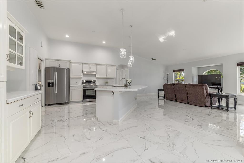 5374 Southeast Horseshoe Point Road Stuart, FL 34997 - Photo 15 of 38 a large white kitchen with cabinets and stainless steel appliances