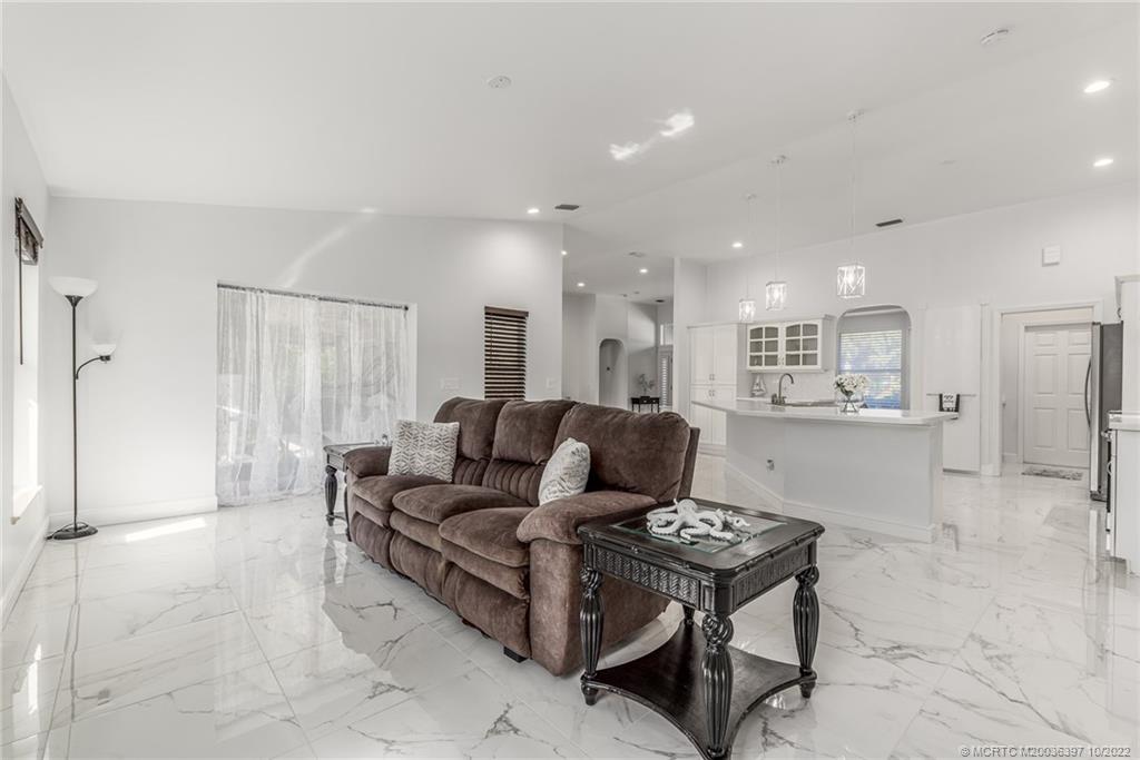 5374 Southeast Horseshoe Point Road Stuart, FL 34997 - Photo 16 of 38 a living room with furniture and a dining table with kitchen view