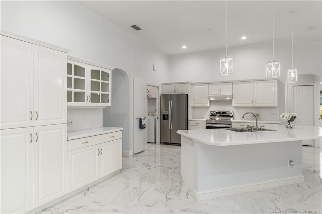5374 Southeast Horseshoe Point Road Stuart, FL 34997 - Photo 17 of 38 a kitchen with stainless steel appliances a sink stove and cabinets
