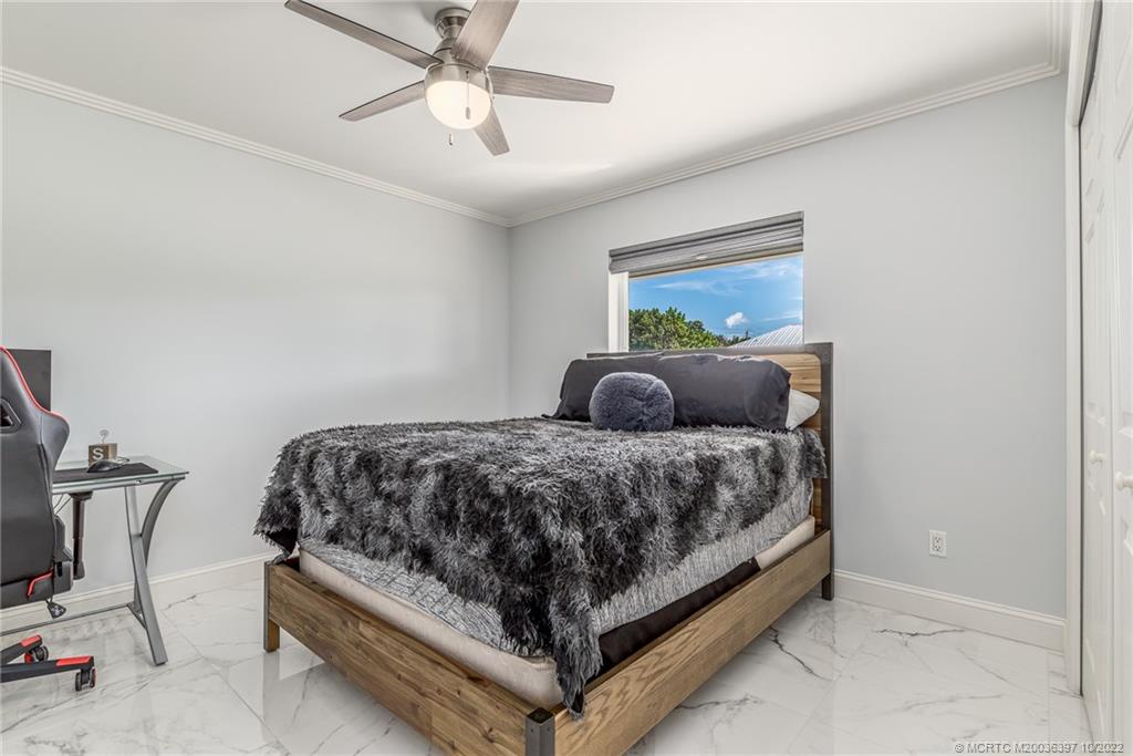 5374 Southeast Horseshoe Point Road Stuart, FL 34997 - Photo 24 of 38 a bedroom with a bed and window