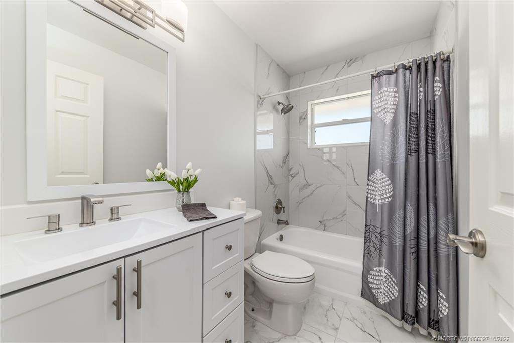 5374 Southeast Horseshoe Point Road Stuart, FL 34997 - Photo 25 of 38 a bathroom with a sink a toilet and shower