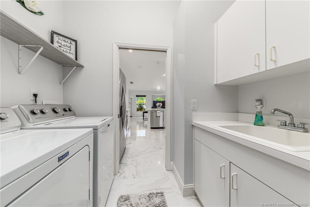5374 Southeast Horseshoe Point Road Stuart, FL 34997 - Photo 26 of 38 a utility room with cabinets washer and dryer