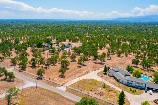 an aerial view of residential houses with outdoor space and trees
