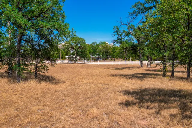 a view of dirt yard with a large tree