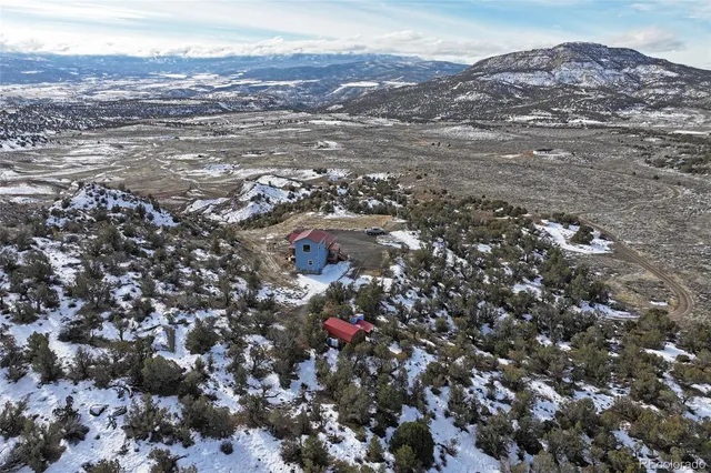 an aerial view of house with yard and mountain view in back