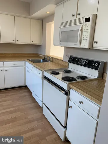 a kitchen with granite countertop a stove sink and cabinets