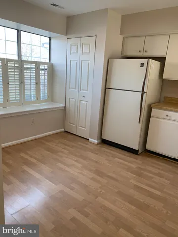 a view of empty room with a kitchen