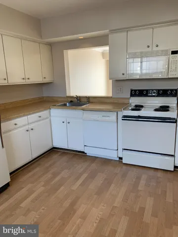 a kitchen with granite countertop white cabinets and white appliances