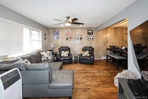 a living room with furniture flat screen tv and window