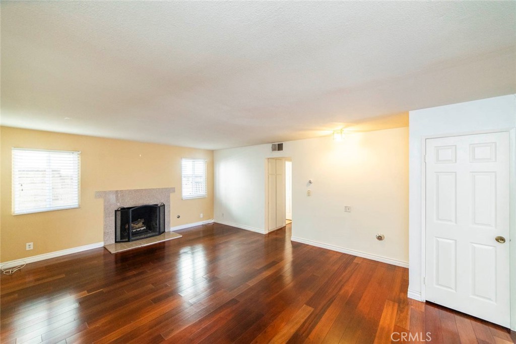 1 Camden Irvine, CA 92620 - Photo 11 of 43 an empty room with wooden floor fireplace and windows