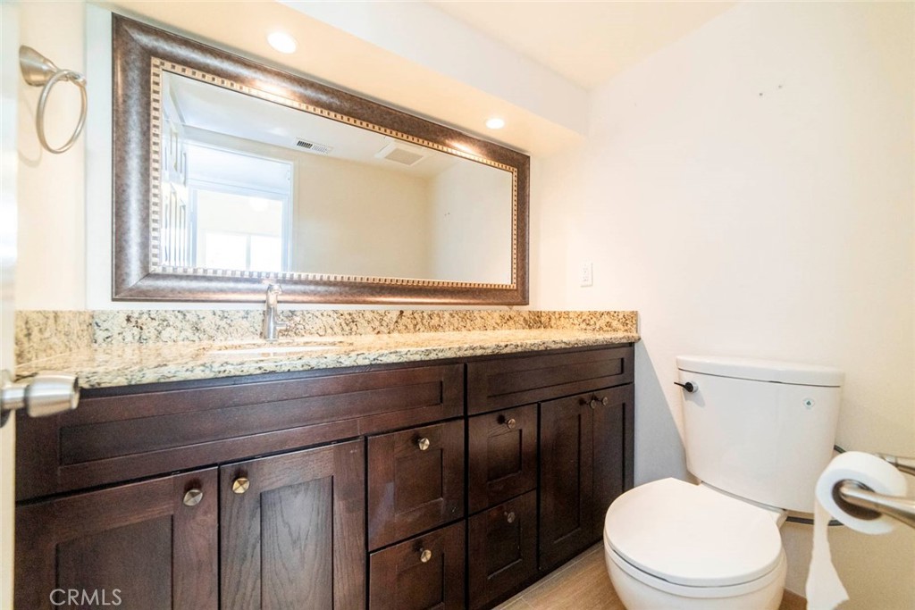 1 Camden Irvine, CA 92620 - Photo 12 of 43 a bathroom with a granite countertop toilet sink and mirror