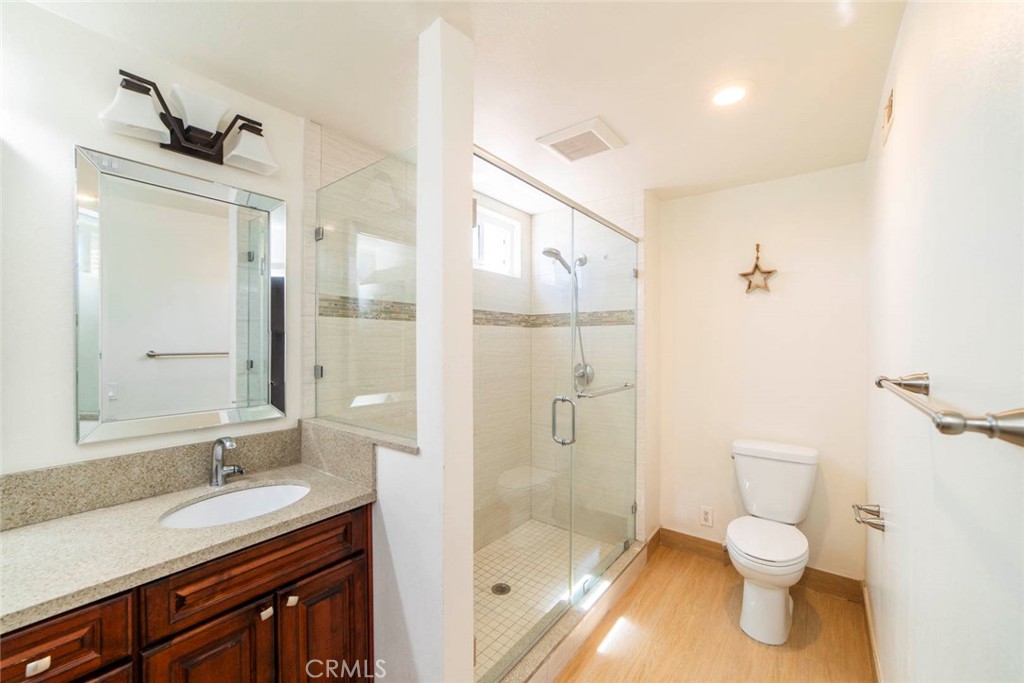 1 Camden Irvine, CA 92620 - Photo 25 of 43 a bathroom with a granite countertop sink toilet a shower and a mirror