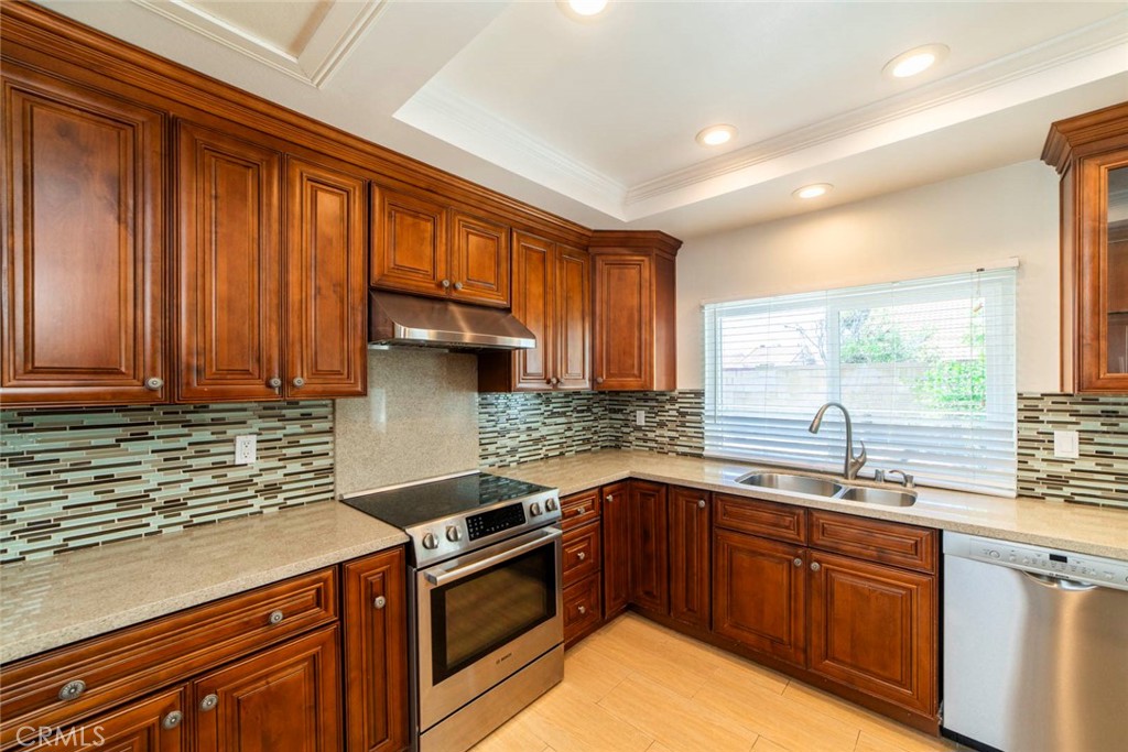 1 Camden Irvine, CA 92620 - Photo 7 of 43 a kitchen with stainless steel appliances granite countertop wooden cabinets a sink and a stove