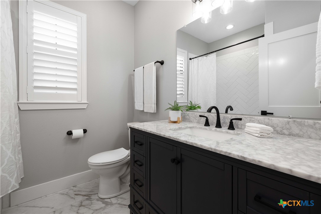 537 Compass Rose Spring Branch, TX 78070 - Photo 21 of 29 a bathroom with a granite countertop sink a toilet and a mirror