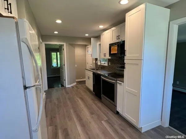 a kitchen with stainless steel appliances granite countertop a refrigerator and a stove top oven
