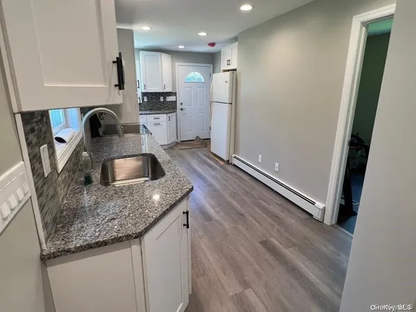 a kitchen with stainless steel appliances granite countertop a sink a stove and a refrigerator