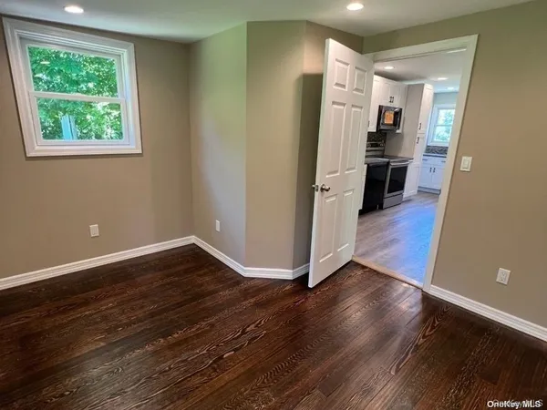 a view of a kitchen with wooden floor and a ceiling fan