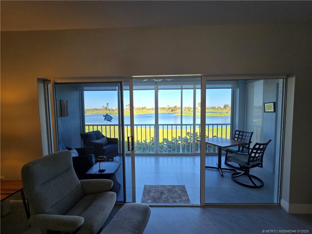 185 Northeast Edgewater Drive, Unit 5105 Stuart, FL 34996 - Photo 11 of 28 a living room with furniture and a floor to ceiling window