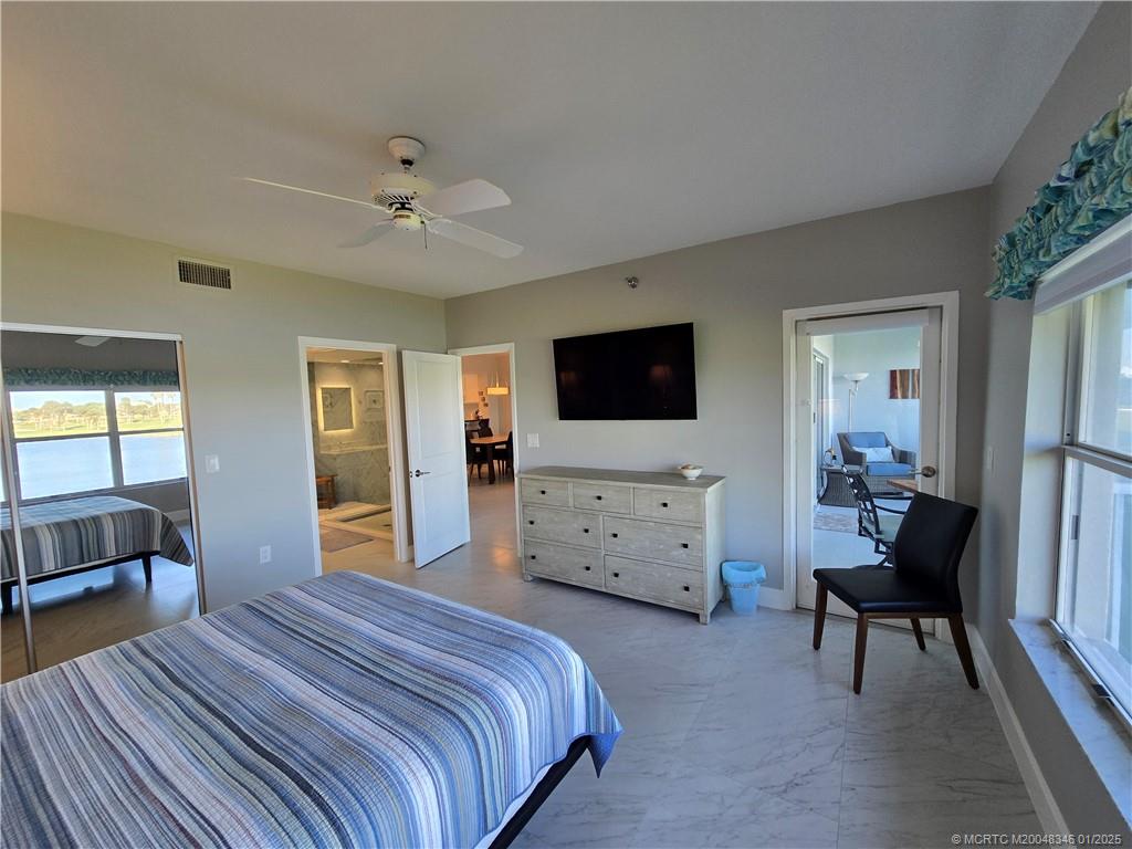 185 Northeast Edgewater Drive, Unit 5105 Stuart, FL 34996 - Photo 18 of 28 a bedroom with a bed and a flat screen tv