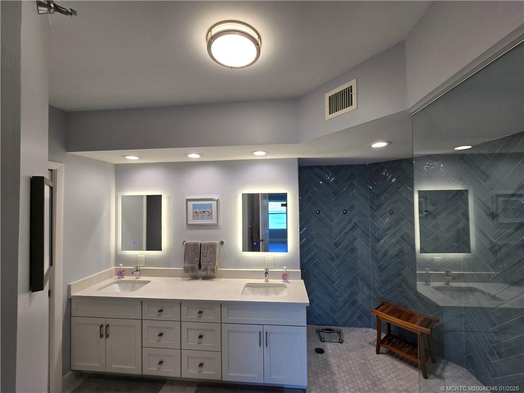 185 Northeast Edgewater Drive, Unit 5105 Stuart, FL 34996 - Photo 22 of 28 a bathroom with a double vanity sink a mirror and a