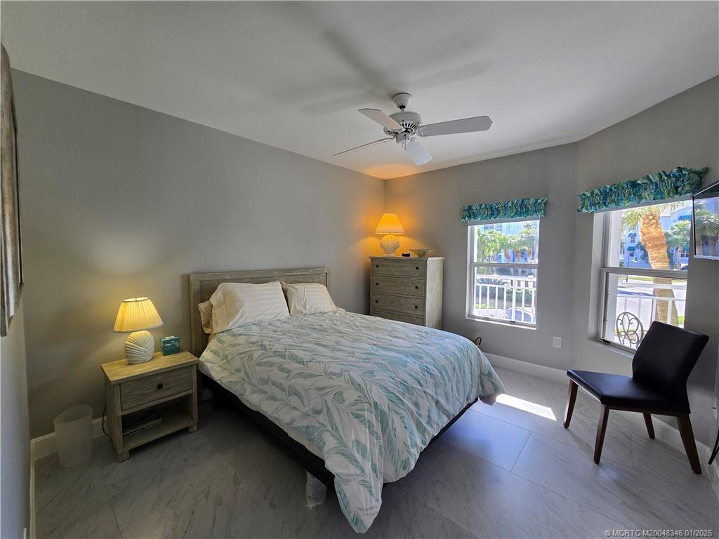 185 Northeast Edgewater Drive, Unit 5105 Stuart, FL 34996 - Photo 24 of 28 a bedroom with a bed a chair and a window