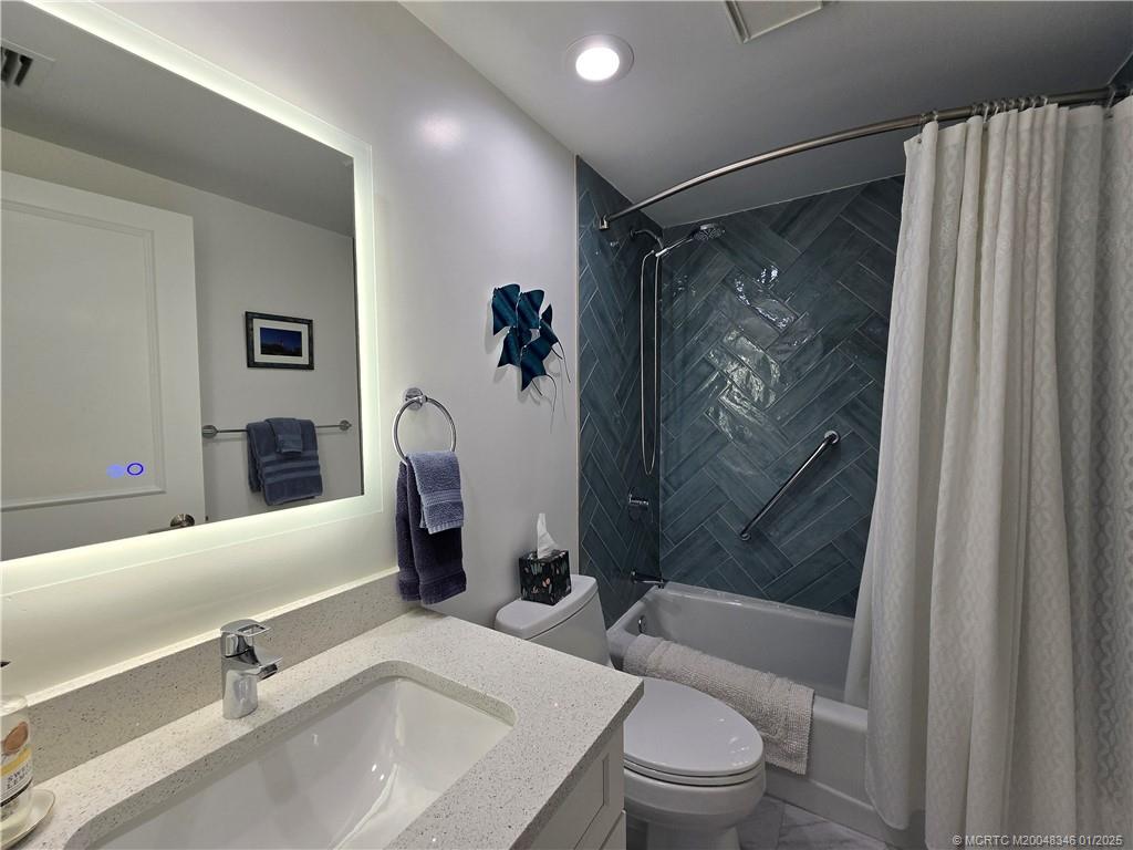 185 Northeast Edgewater Drive, Unit 5105 Stuart, FL 34996 - Photo 25 of 28 a bathroom with a sink toilet and shower