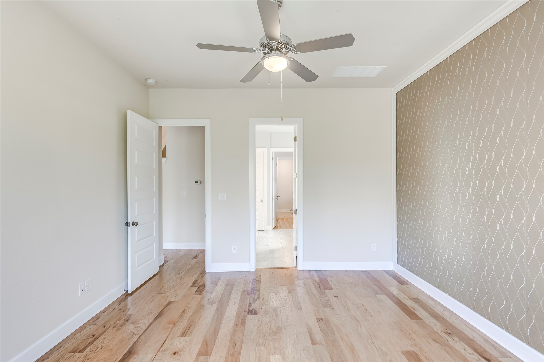 345 Fort Cobb Way Georgetown, TX 78628 - Photo 20 of 38 Hardwood floors and a textured feature wall define this versatile secondary bedroom space.