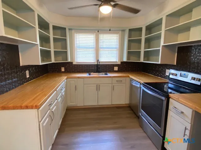 a kitchen with a sink stove and cabinets