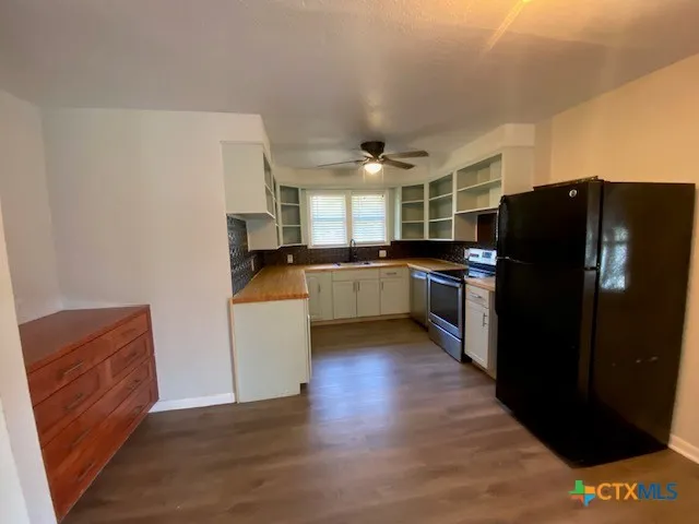 a kitchen with stainless steel appliances granite countertop a refrigerator and a stove top oven
