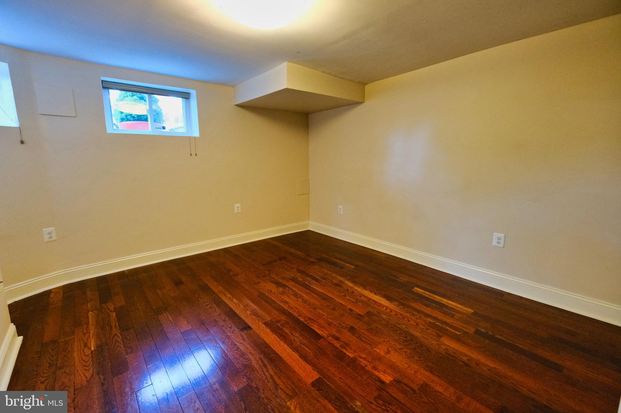 2225 Brookfield Avenue Baltimore, MD 21217 - Photo 7 of 28 a view of an empty room with wooden floor and a window