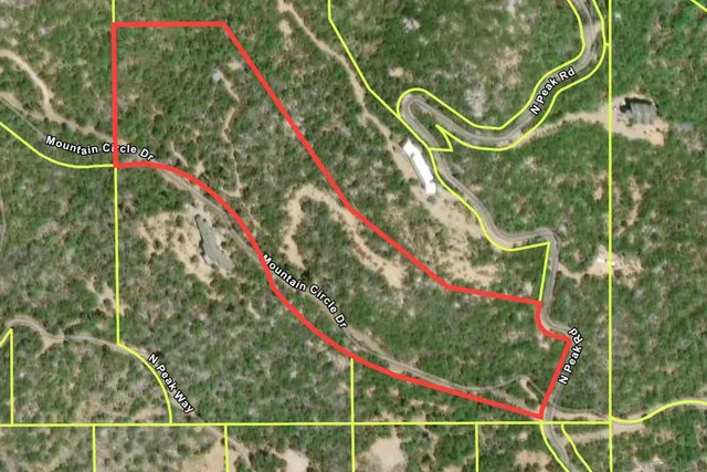 a green field with lots of trees in the background