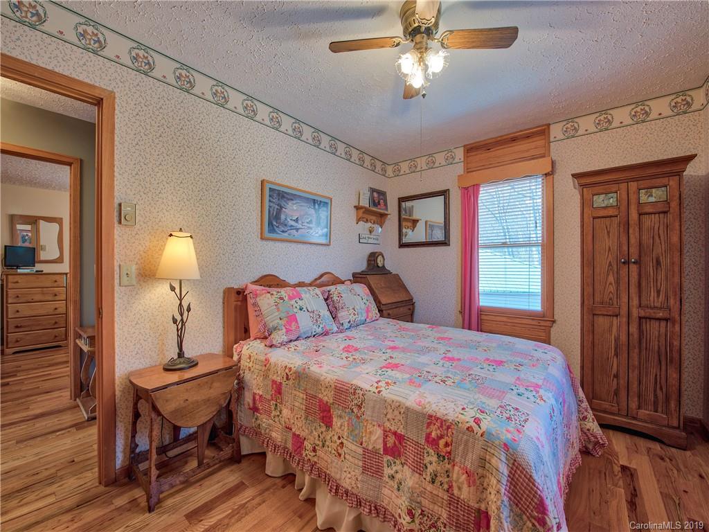 464 Bent Tree Road Maggie Valley, NC 28751 - Photo 13 of 38 a bedroom with a bed and a chandelier