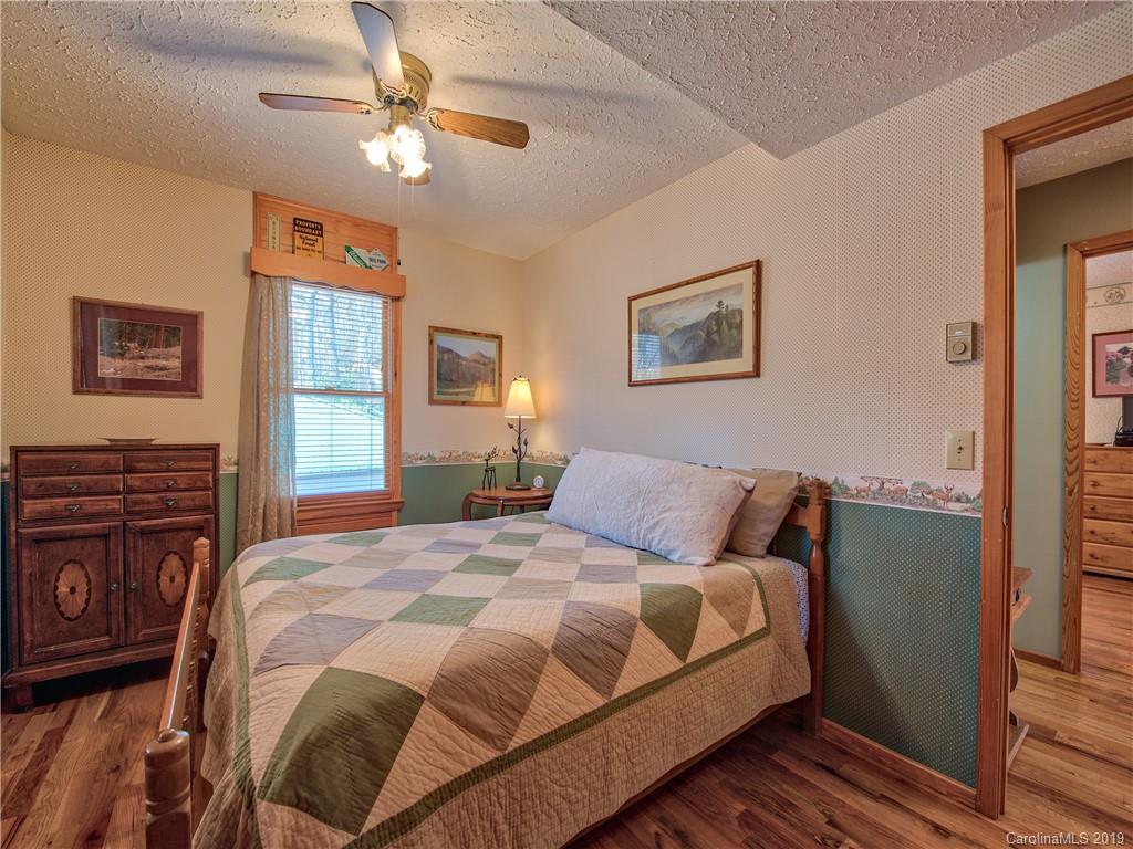 464 Bent Tree Road Maggie Valley, NC 28751 - Photo 15 of 38 a bedroom with a large bed dresser and window