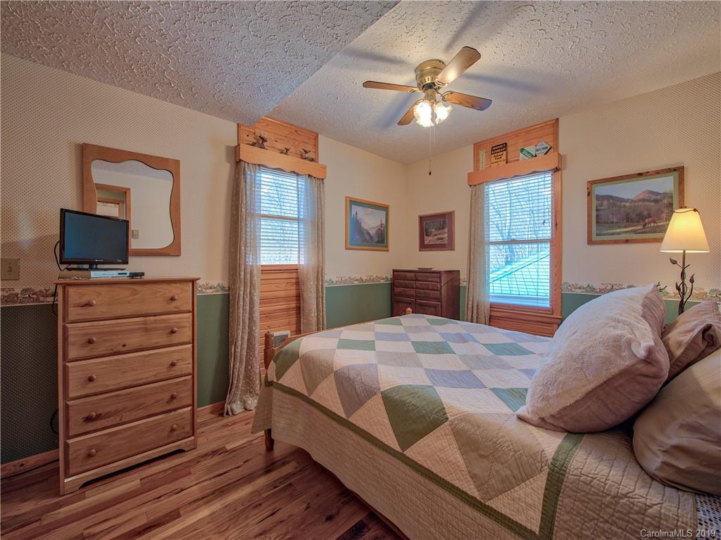 464 Bent Tree Road Maggie Valley, NC 28751 - Photo 16 of 38 a bedroom with a bed and wooden floor
