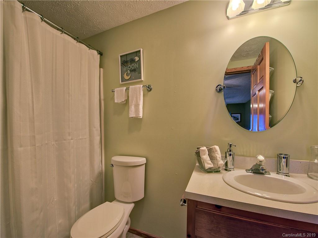 464 Bent Tree Road Maggie Valley, NC 28751 - Photo 21 of 38 a bathroom with a sink a toilet and mirror