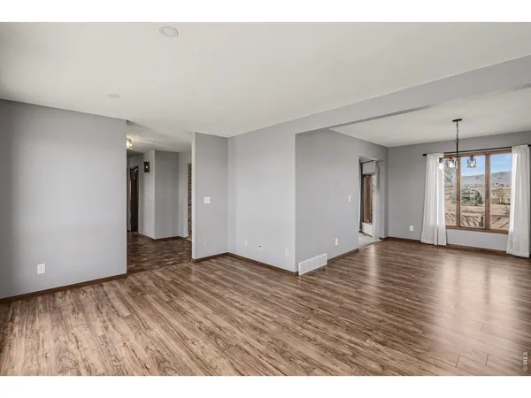 a kitchen with a stove a sink a refrigerator and wooden floor
