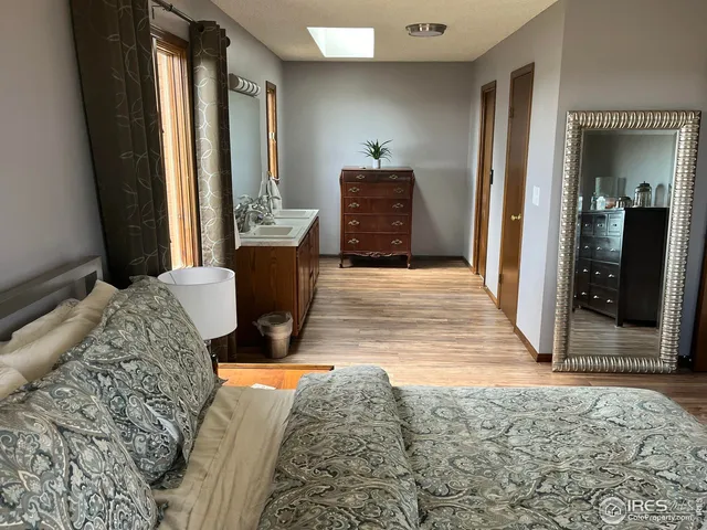 a bedroom with a bed and dresser with mirror