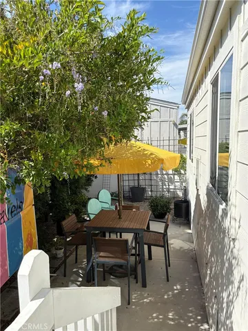 a patio with a table and chairs under an umbrella