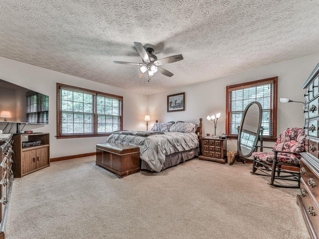 2760 Hembree Road Northeast Marietta, GA 30062 - Photo 18 of 65 a spacious bedroom with a bed a chandelier and a couch