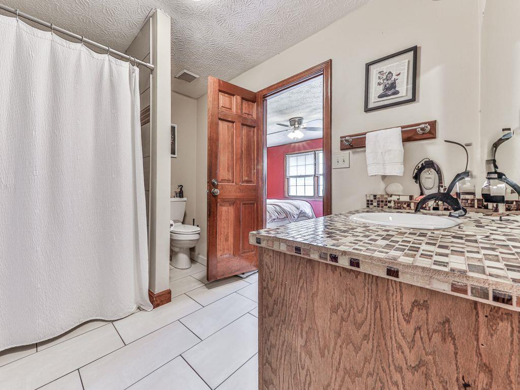 2760 Hembree Road Northeast Marietta, GA 30062 - Photo 44 of 65 a bathroom with a granite countertop sink a mirror and a shower