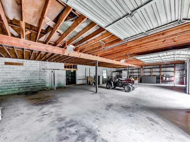an aerial view of a residential houses with outdoor space and trees