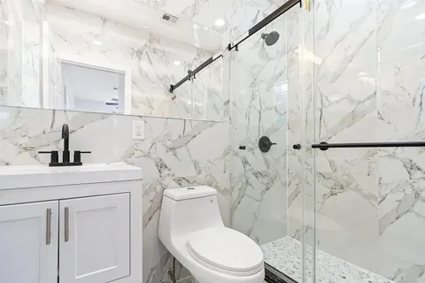 a bathroom with a sink a toilet and shower